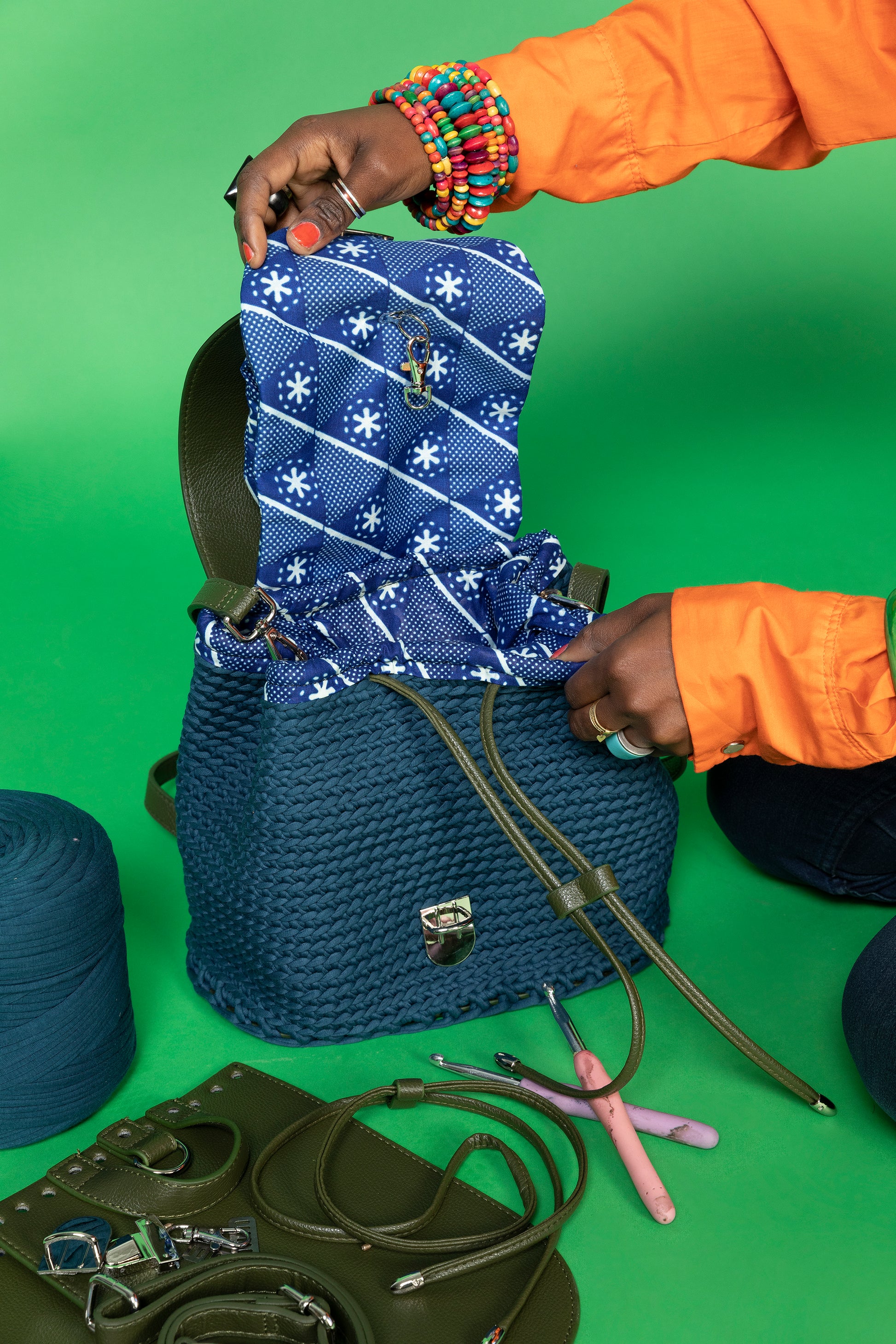 crocheted, dark blue and forest green bag, with an African style print. opened showing compartments.