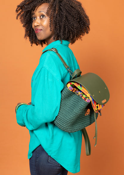 crocheted, forest/ oak green bag, with an African style print. Model shown wearing bag as a backpack. 