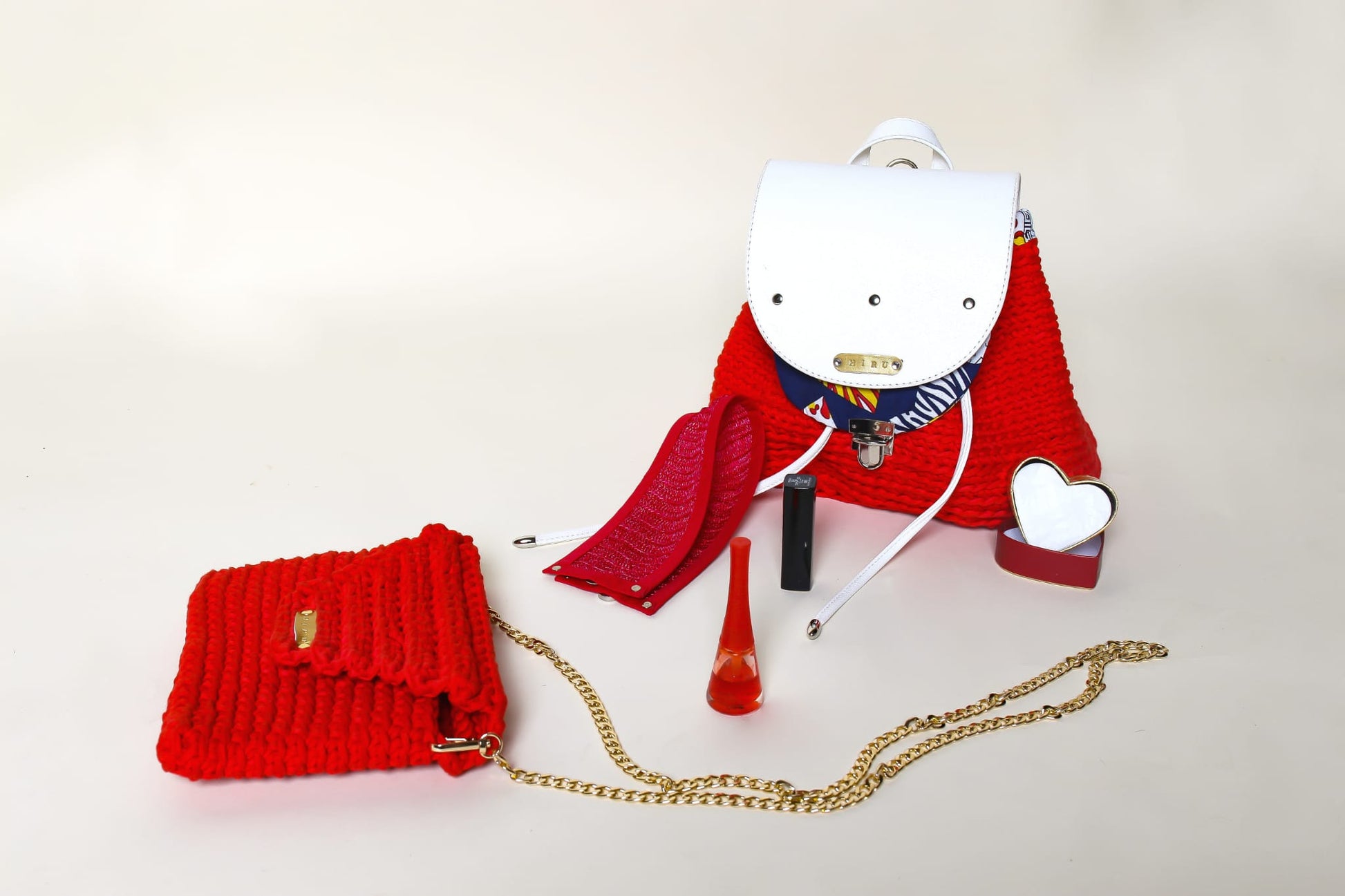 crocheted, red and white bag, with an African style print. Shown with a red crocheted clutch bag and red neackwear accessory. 